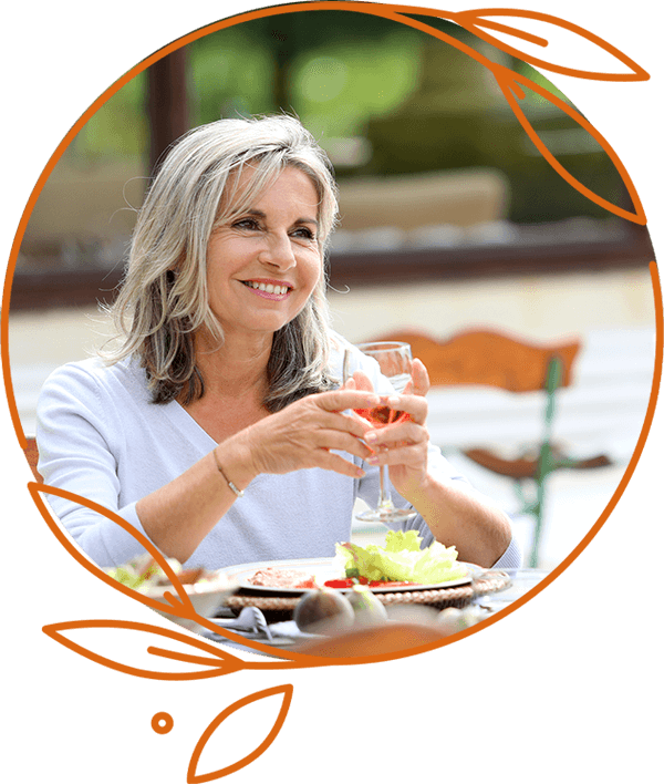 Very nice lady smiling eating food outside holding up a cup of wine